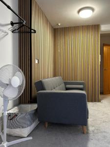a living room with a couch and a fan at Entire Apartment boutique king size bed near Town Centre in Colchester