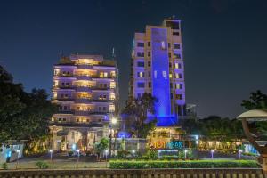 two tall buildings are lit up at night at 1O1 URBAN Jakarta Thamrin in Jakarta