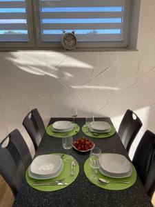a table with plates and glasses and a plate of food at Ferienwohnung Zur alten Dorfschule in Lünebach +9 photos