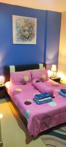 a bedroom with a pink bed with a pink blanket at Relaxing Retreats at Cocobay Apartments in Port Dickson