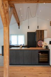 a kitchen with black cabinets and a wooden floor at 12er Huus in Bürserberg
