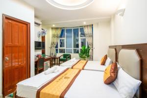 頭頓的住宿－Khanh Vy Hotel，一间卧室设有两张床、一张桌子和一个窗口。