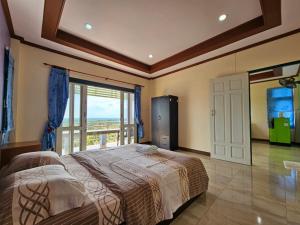 a bedroom with a bed with a view of the ocean at Baan Khao Noi Resort in Surat Thani