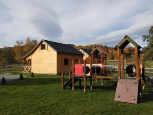 un parque infantil frente a un edificio con una casa en Sudecka Wiata-Domki, en Głuszyca