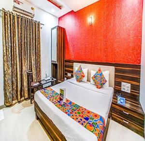 a bedroom with a bed and a red wall at FabHotel The Adore Palace in Mumbai