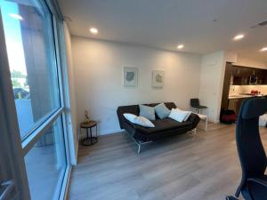 sala de estar con sofá negro y cocina en Luxurious Apartment Bardeen New Port Beach 1 Bedroom, en Irvine
