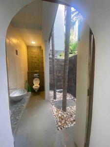 a bathroom with a toilet in a room with rocks at Palm 3Bhk Villa Alibaug in Alībāg