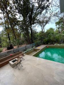 a swimming pool with a chair and a bench next to it at Palm 3Bhk Villa Alibaug in Alībāg