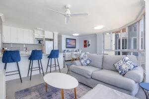 a living room with a couch and a kitchen at Oceanview Holiday Accommodation in Bloubergstrand