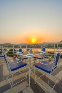 a table and chairs on a balcony with the sunset at Royal Rafahiya Haveli - LAKE FACING in Udaipur
