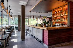 a bar in a restaurant with tables and chairs at Adler Resort in Saalbach-Hinterglemm