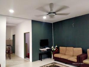 a living room with a couch and a ceiling fan at Sri Manik Guest House Tanjung Karang in Tanjung Karang