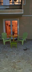 un patio con mesa y 2 sillas verdes en Lovely place with a view of Skopje, en Skopje