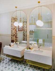 un baño con dos lavabos y dos espejos en Oryx Boutique Hotel, en Klerksdorp