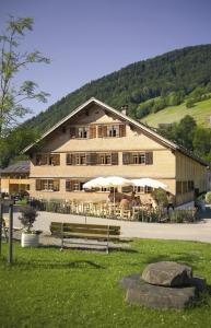 ein großes Gebäude mit einer Bank davor in der Unterkunft Naze`s Hus Mellau in Mellau