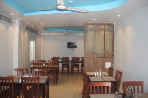 una sala da pranzo con tavoli, sedie e soffitto di Hotel Serene Palace a Port Blair
