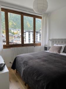 um quarto com uma cama grande e uma janela grande em Appartement Oliver em Chamonix-Mont-Blanc