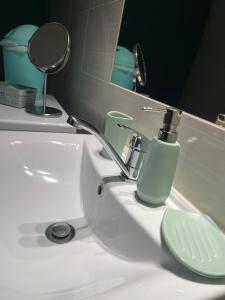- un lavabo dans la salle de bains avec un distributeur de savon dans l'établissement Veľký apartman, à Karlova Ves