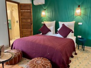 een slaapkamer met een groot bed en een paarse deken bij RIAD SHANAM Location Privative in Marrakesh