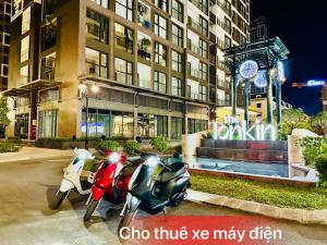 um grupo de scooters estacionado em frente a um edifício em Homestay Smart - Vinhomes Tu Liem Ha Noi em Hanói