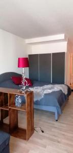 1 dormitorio con 1 cama y 1 mesa con lámpara en Tegernsee Apartment 2 min zum See en Tegernsee