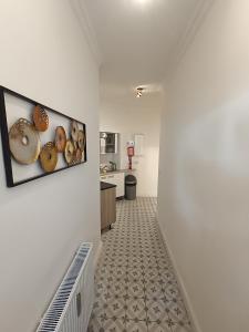 un pasillo que conduce a una cocina con una foto de donuts en la pared en central 2Room Apartment XBerg en Berlín