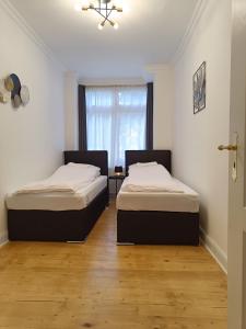 two beds in a room with a window at central 2Room Apartment XBerg in Berlin