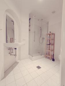 a white bathroom with a shower and a sink at central 2Room Apartment XBerg in Berlin