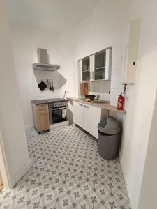 a kitchen with a tile floor and white cabinets at central 2Room Apartment XBerg in Berlin
