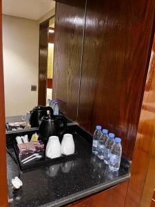 a kitchen with bottles of water on a counter at فندق كونكورد دار الخير - المدينة الشمالية in Al Madinah