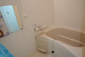 Baño blanco con lavabo y espejo en Orange House 702, en Osaka