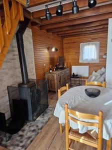 a room with a fireplace and a table and a stove at Petit chalet individuel à Font-romeu in Font-Romeu-Odeillo-Via