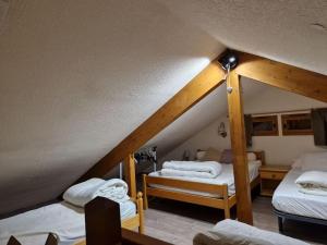 a attic room with three beds and a staircase at Petit chalet individuel à Font-romeu in Font-Romeu-Odeillo-Via
