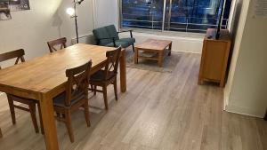 - une salle à manger avec une table et des chaises en bois dans l'établissement Chambre calme (Mercure) - proche Paris et TGV, à Massy