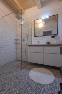 ein Bad mit einer Dusche, einem Waschbecken und einem Spiegel in der Unterkunft Renesanční vinařský dům v historickém centru Znojma in Znojmo