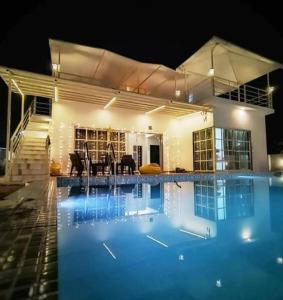 uma casa com piscina à noite em SHER 3BHK VILLA ALIBAUG em Alibaug