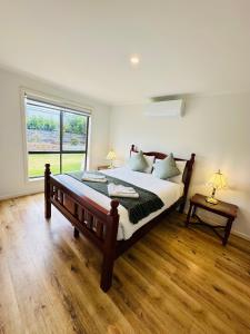 キングズコートにあるKangaroo Island Homestaysのベッドルーム(大型ベッド1台、窓付)