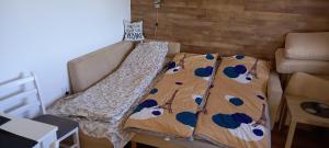 ein kleines Bett in einem kleinen Zimmer mit einem Bettlaken mit Kühen in der Unterkunft Apartman Narcis Polje 3 in Divčibare