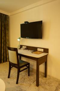 a desk with a chair and a television on a wall at Fairfield by Marriott Pune Kharadi in Pune