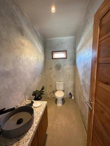 uma casa de banho com um lavatório e um WC em Gamelan Amed Villa em Amed