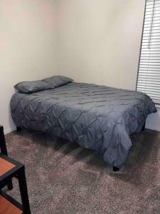a bed in the corner of a room at Everything you need to call home in Norman