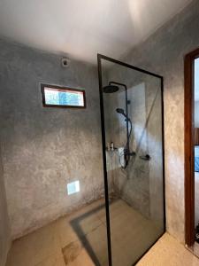 um chuveiro com uma porta de vidro na casa de banho em Gamelan Amed Villa em Amed