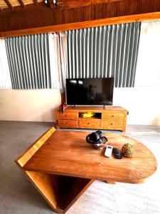 uma mesa de café em madeira numa sala de estar com televisão em Gamelan Amed Villa em Amed
