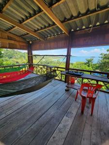 a wooden deck with a picnic table and a hammock at Sweet View Guesthouse in Kaôh Rŭng (3)