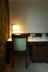 a desk with a chair and a desk with a lamp at Fairfield by Marriott Pune Kharadi in Pune