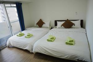 大阪市にあるOrange House 701のベッド2台(ライムグリーンのタオル付)