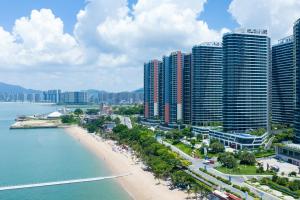 uma vista de uma praia e alguns edifícios altos em Poltton Century Hotel em Huizhou