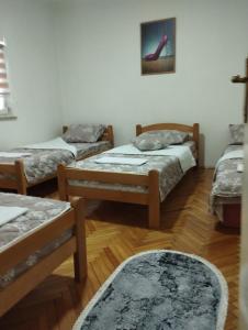 a room with three beds and a rug at Apartman Milicevic in Bileća