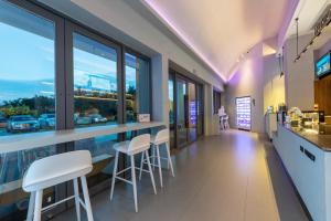 a restaurant with a bar with white stools at Platinum Century Hotel in Huizhou