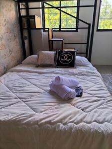 uma cama branca com duas toalhas em cima em le melur guest house em George Town